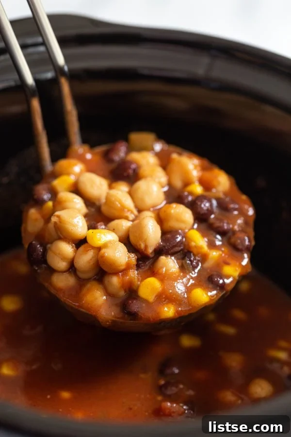 A slow cooker filled with the vibrant chickpea taco soup, showcasing the rich colors of salsa, black beans, and chickpeas before cooking.