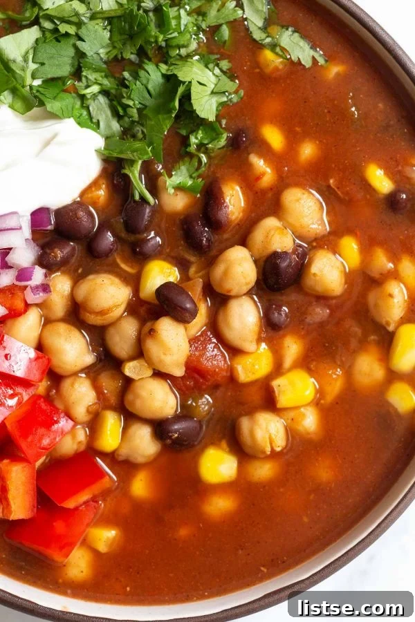 A close-up of chickpea taco soup in a bowl, highlighting the colorful blend of chickpeas, black beans, and corn.