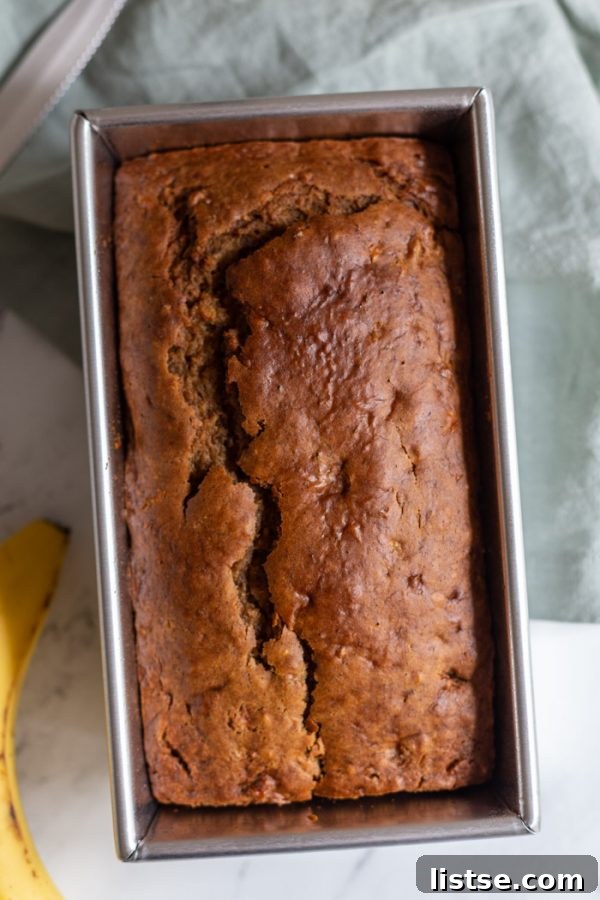 Plant-Powered Banana Loaf 3 A freshly baked loaf of Vegan Banana Bread in a baking pan, cooling.