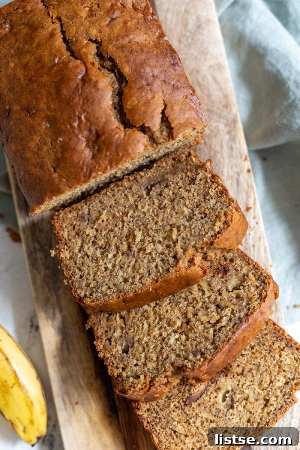 Plant-Powered Banana Loaf 5 Multiple slices of vegan banana bread arranged on a wooden serving board.