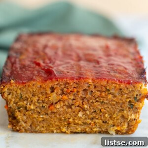 A slice of hearty Vegan Meatloaf on a plate, showcasing its appealing texture and rich color, ready to be served. A delicious and satisfying plant-based main course.