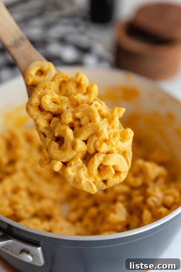 A spoonful of rich, golden easy vegan mac and cheese, highlighting its smooth texture.
