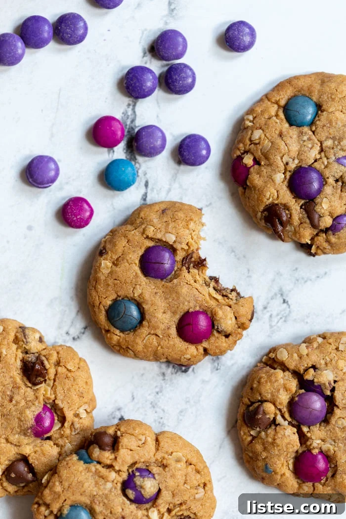 A freshly baked vegan monster cookie on a cooling rack, showcasing its vibrant candies and rich texture.