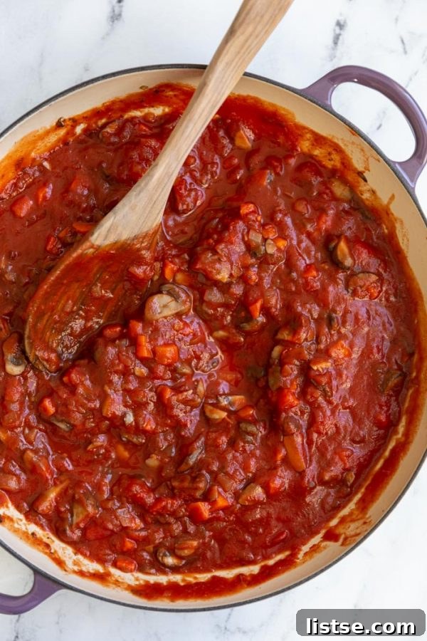 Rich vegetable and tomato sauce simmering in a skillet, ready for lasagna