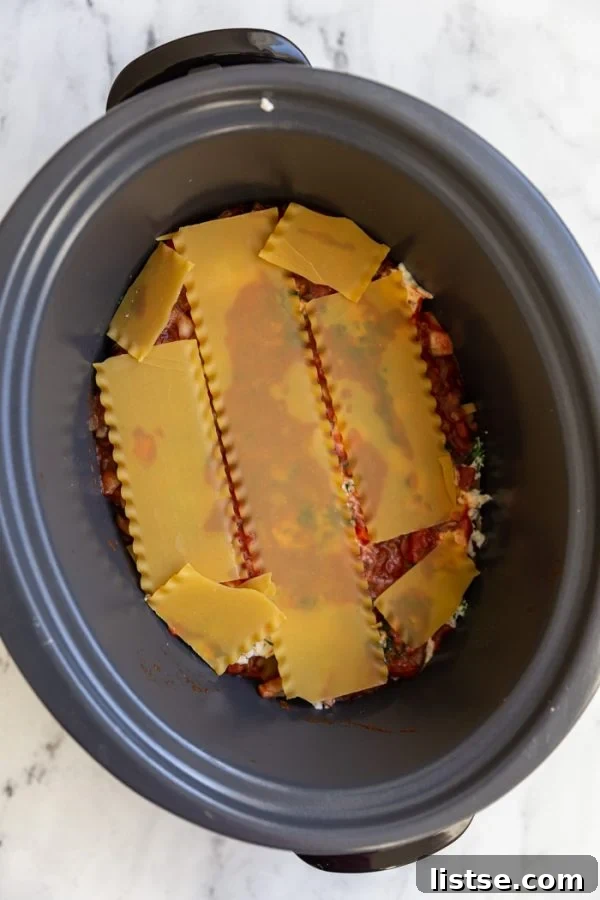 Step-by-step layering of vegetarian lasagna in a slow cooker