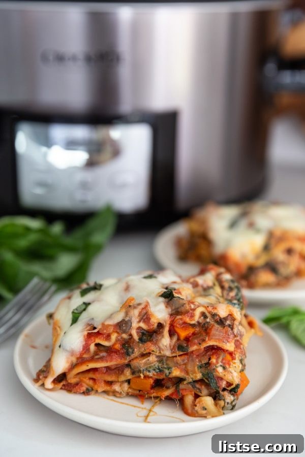 A freshly cooked vegetarian lasagna in a slow cooker, ready to be served, topped with melted mozzarella
