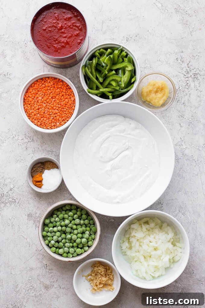 A collection of fresh ingredients for making lentil curry, arranged in small bowls.