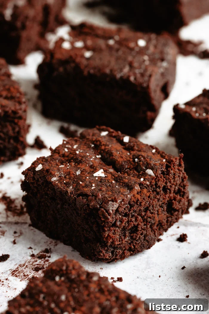 Vegan brownies sprinkled with sea salt, arranged on a white background.