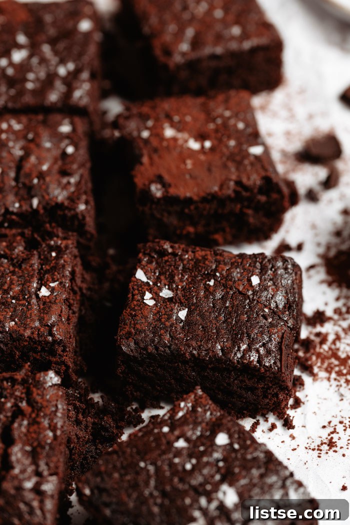 An artfully arranged display of vegan brownies, generously sprinkled with flaky sea salt.
