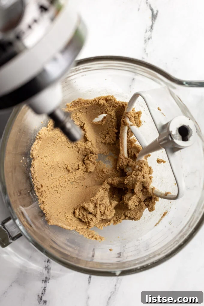 Creamy mixture of brown sugar and vegan butter in a stand mixer bowl, ready for the next steps.