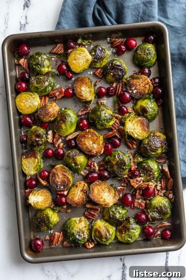 Roasted Brussels sprouts and cranberries on a baking tray, ready to serve.