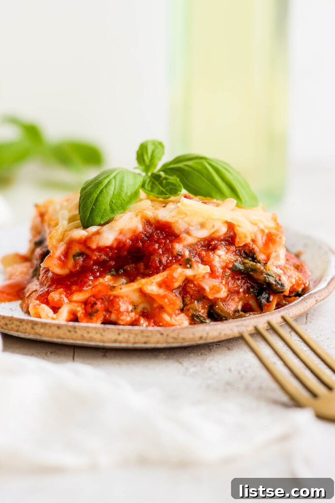 Ultimate Vegan Lasagna 2 Vegan lasagna on a plate garnished with basil.