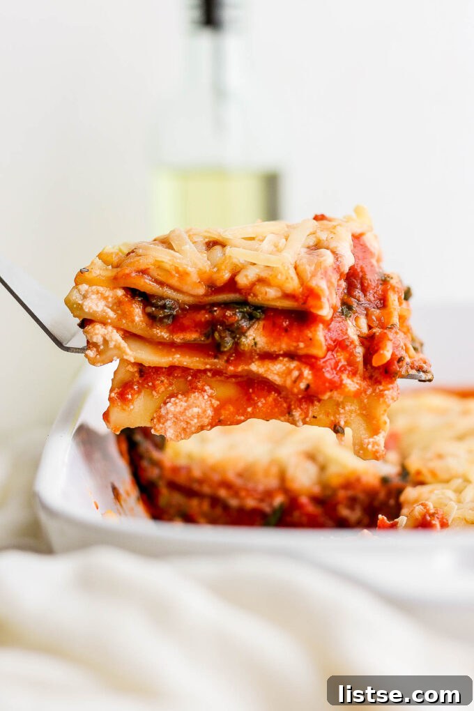 Ultimate Vegan Lasagna 3 Scooping a slice of lasagna from a baking dish.