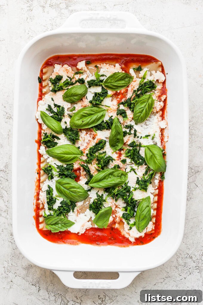 Ultimate Vegan Lasagna 4 Adding basil leaves on lasagna.