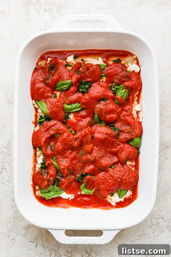 Ultimate Vegan Lasagna 5 Adding spaghetti sauce layer to lasagna.