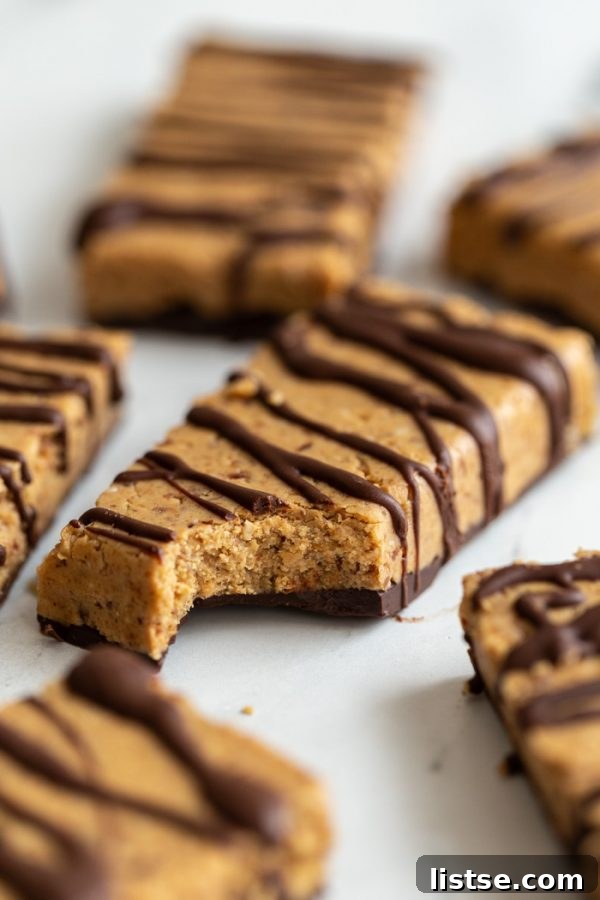 Homemade Vegan Protein Bars drizzled with chocolate on a white tabletop, ready to be enjoyed as a healthy plant-based snack.