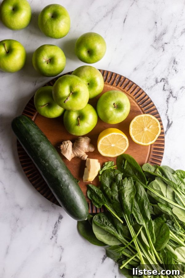 Green Apple Revival 4 A selection of fresh ingredients for green juice: vibrant green apples, a cucumber, a lemon, a piece of fresh ginger, and a generous pile of spinach leaves.
