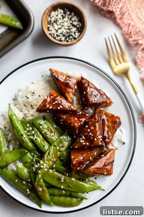 Tempeh Smokehouse Bowls 2 smoked tempeh and sugar snap peas on white rice in a white bowl, garnished with sesame seeds
