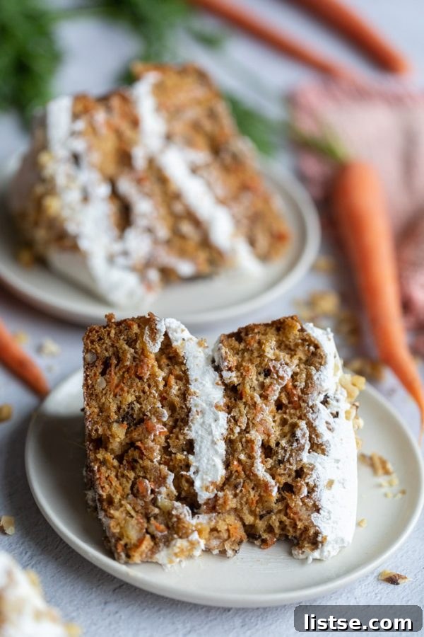 2 slices of vegan carrot cake with frosting on top, garnished with nuts