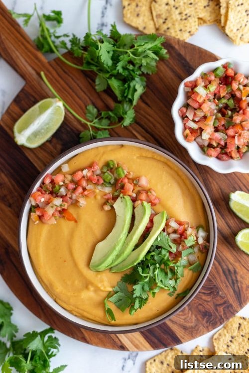 Smooth and savory vegan nacho cheese sauce, perfect for dipping chips and drizzling over plant-based party food