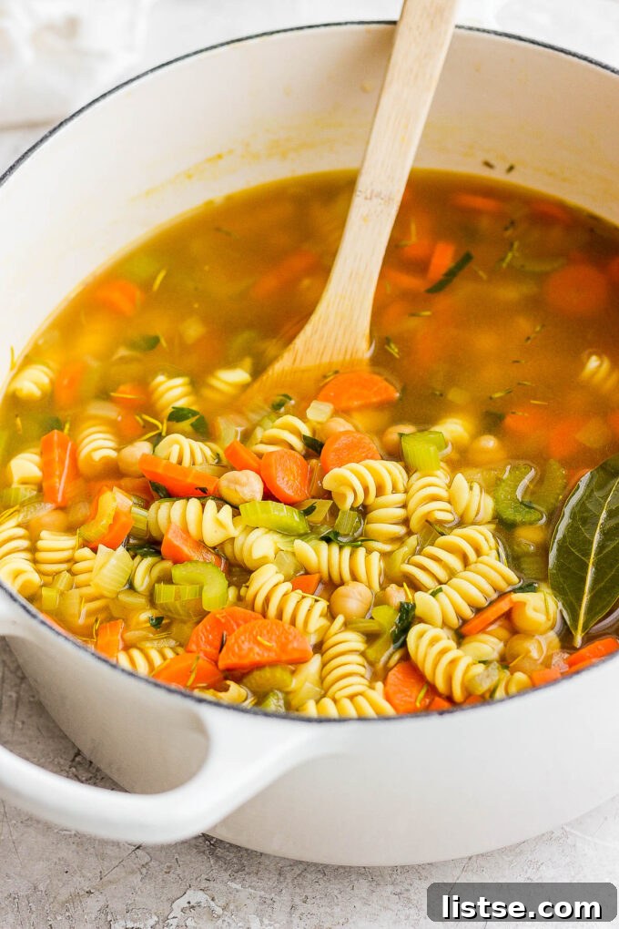 Golden Chickpea Noodle Hug 7 The delicious chickpea noodle soup bubbling gently in a large pot on the stove.
