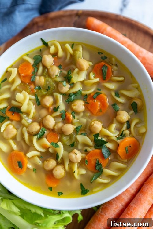 Hearty chickpea noodle soup in a white bowl