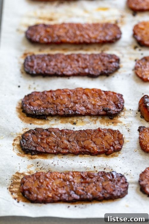 Tray of savory tempeh bacon slices on parchment paper