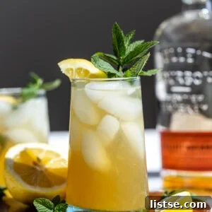 A refreshing Whiskey Smash cocktail, garnished with lemon and mint.