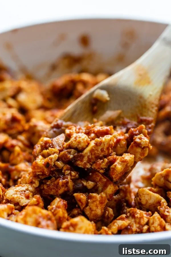 Up close side angle shot of sofritas in a skillet with a spoonful being taken out