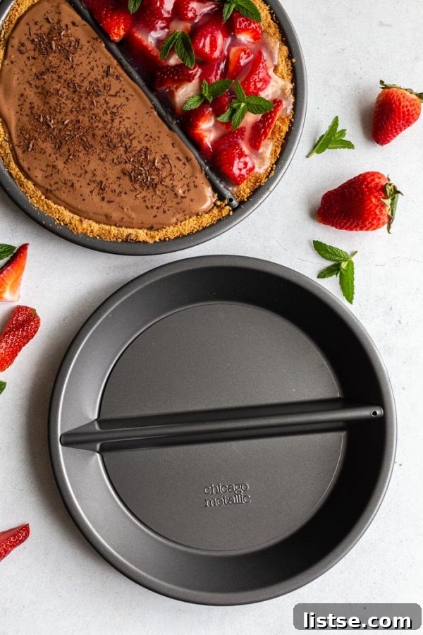 Sweet Divide Pie: Strawberry & Chocolate 4 Double-sided 'split decision pie' featuring a chocolate silken pie on one side and a fresh strawberry pie on the other, with fresh strawberries and mint around the frame. This image also shows a full pie dish alongside an empty one, highlighting the pan's design.