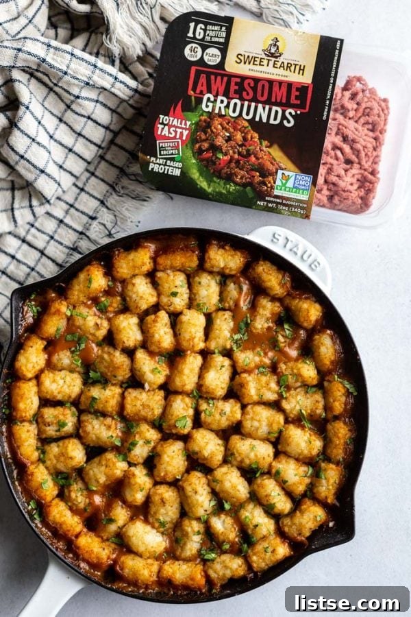 A close-up shot of the creamy vegan filling for the tater tot casserole, showcasing mushrooms and plant-based grounds, before adding the tater tots.