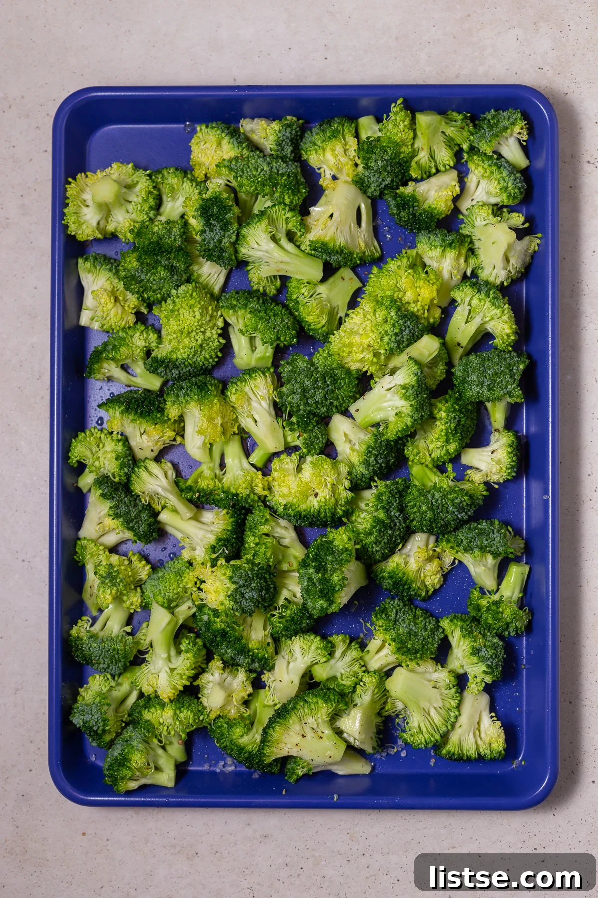 broccoli florets on a blue baking sheet