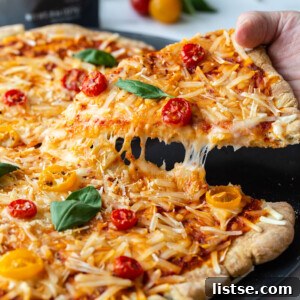 Smoky Plant-Based Grilled Pizza 8 Hand picking up a slice of pizza.