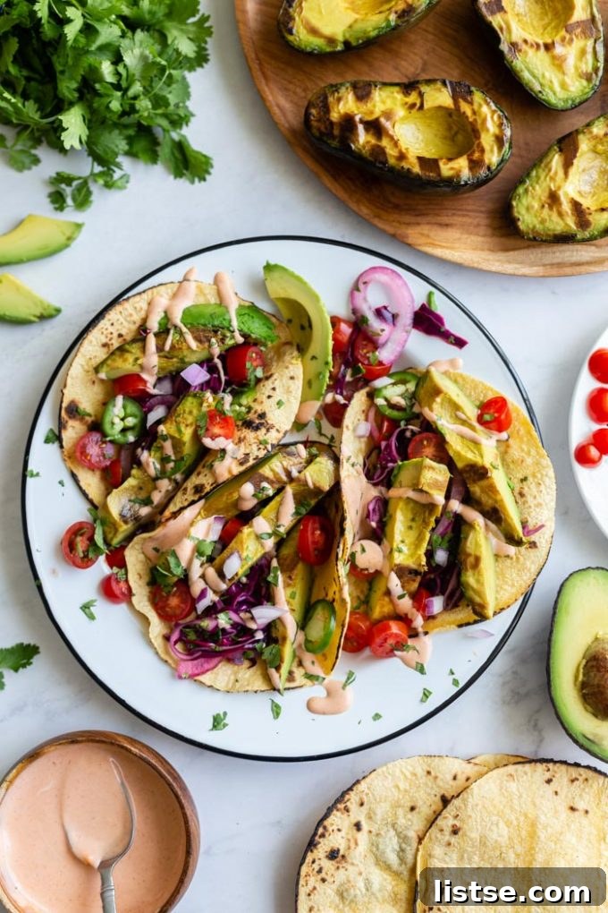 Delicious grilled avocado tacos served on a plate with fresh toppings, perfect for summer.