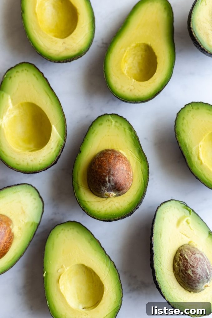 Close-up shot of grilled avocado halves with perfect char marks, ready for slicing.