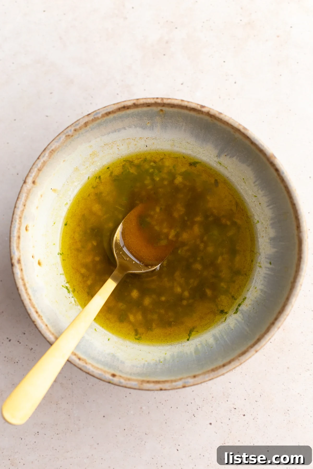 bowl with lime dressing in it and a gold spoon