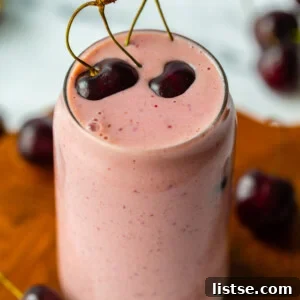 Vibrant pink cherry smoothie in a glass, ready to be enjoyed.