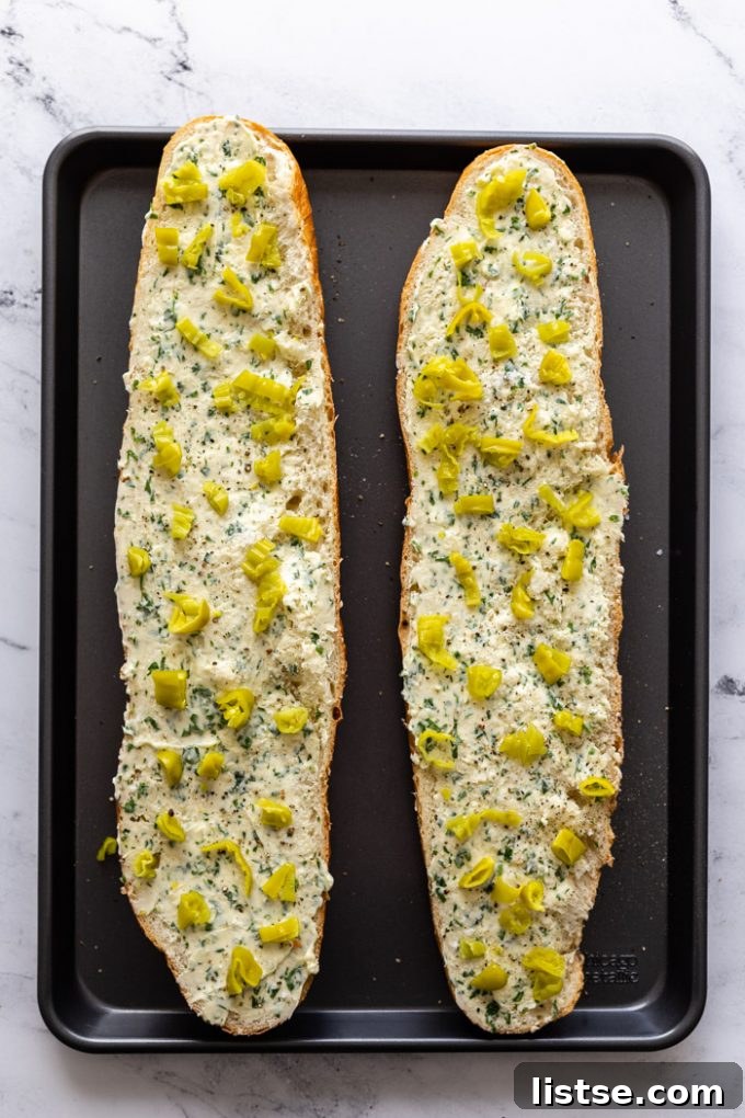 Spicy Peperoncini Garlic Bread 4 Two halves of peperoncini garlic bread on a baking tray, ready to be served.