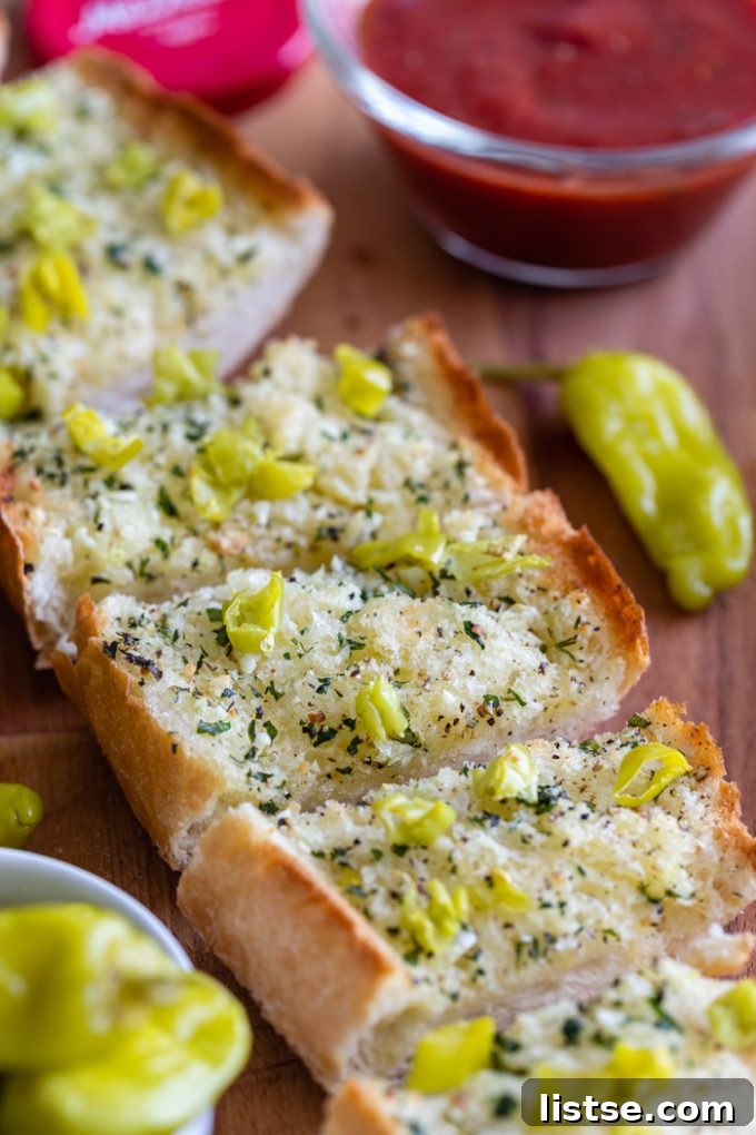 Spicy Peperoncini Garlic Bread 6 Close-up of peperoncini garlic bread slices, with marinara sauce in the background.