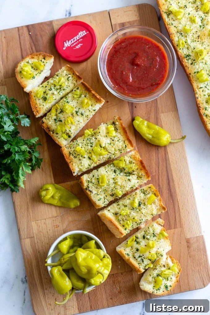 Spicy Peperoncini Garlic Bread 7 Piles of sliced peperoncini garlic bread next to a small bowl of marinara dipping sauce.