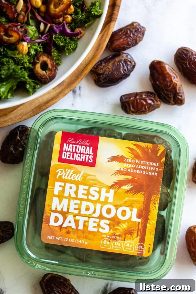 up close shot of a green box of Natural DelightsPitted Fresh Medjool Dates. a kale date salad is in the corner with fresh dates all around