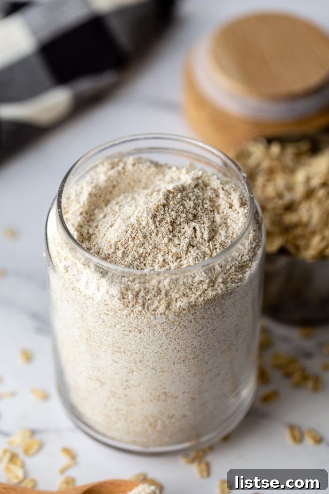 glass container filled with oat flour and fresh oats in the background