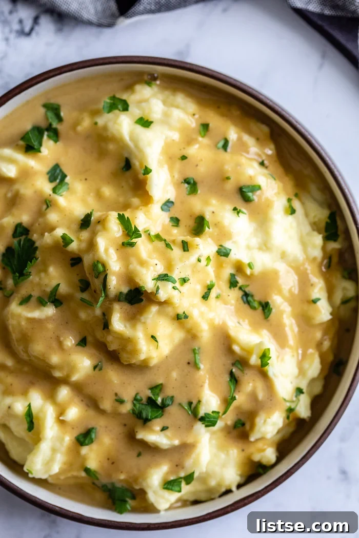 Effortless Vegan Gravy 2 big bowl of mashed potatoes covered with a brown vegan gravy sauce and sprinkled with fresh herbs