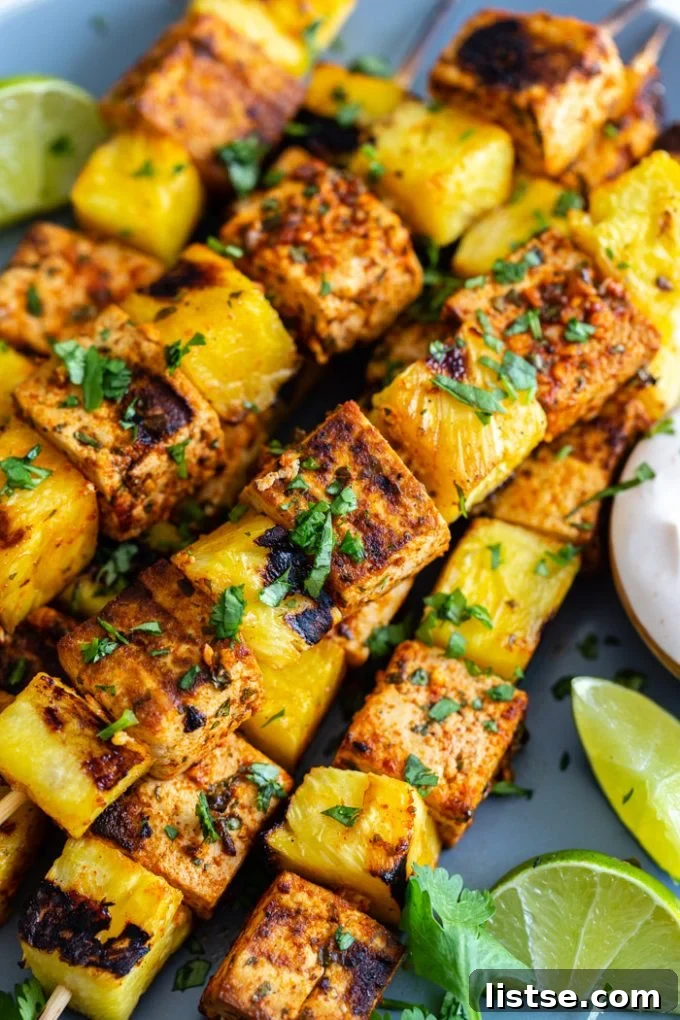 up close shot of grilled skewers with tofu and pineapple sprinkled with cilantro and lime juice
