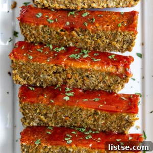 Hearty Plant-Based Loaf 7 plate with slices of vegan meatloaf on it sprinkled with fresh herbs