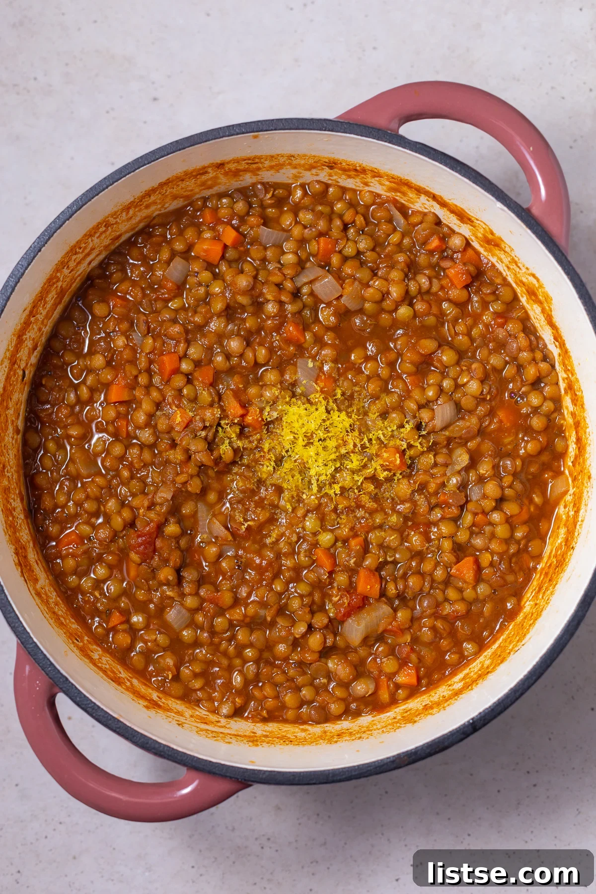 One-Pot Vegan Lentil Soup 7 ingredients for lentil soup in a pot. lemon zest is on top
