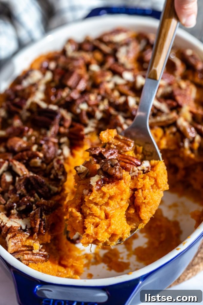 Wholesome Vegan Sweet Potato Bake 3 serving a portion of vegan sweet potato casserole with candied pecans from a casserole dish