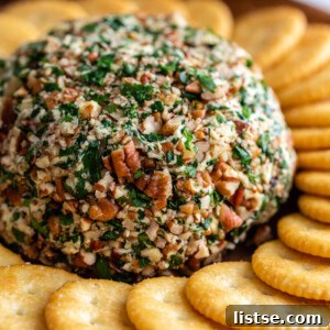 vegan cheeseball covered in chopped pecans and served with Ritz crackers