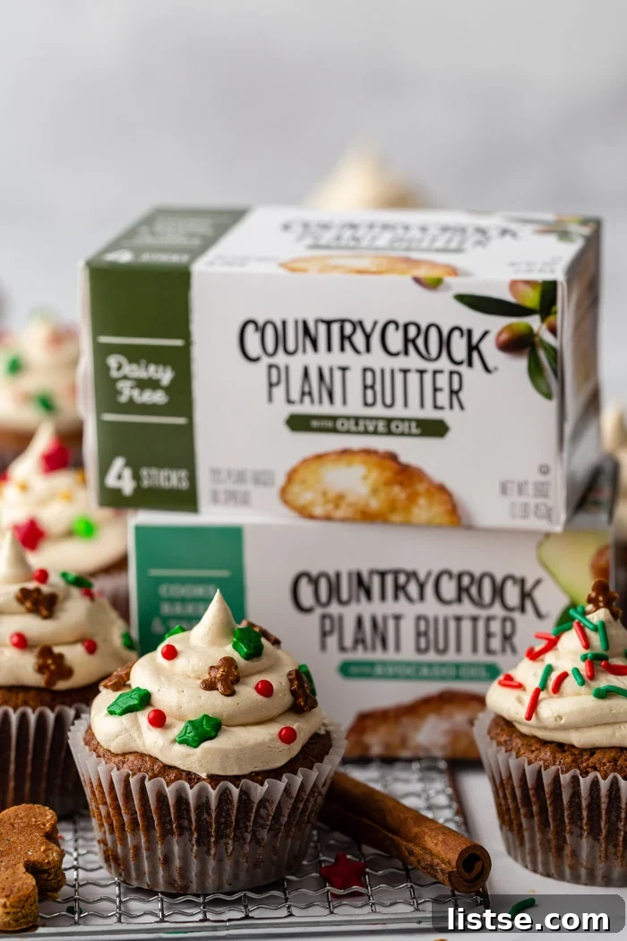 Spiced Gingerbread Cupcakes 4 Assortment of gingerbread cupcakes with charming gingerbread men sprinkles, with Country Crock Plant Butter cartons visible in the background, emphasizing its vegan and sustainable aspects.
