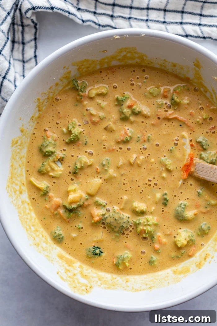 A large, pristine white bowl filled with a creamy, pale yellow chickpea flour mixture, ready to be transformed into savory vegan "egg" cups.